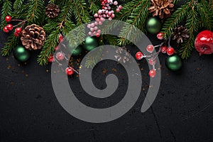 Christmas Decoration. Holiday Decorations with baubles, fir branches and present on dark black background. Border design. Top view