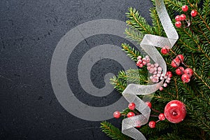 Christmas Decoration. Holiday Decorations with baubles, fir branches and present on dark black background. Border design. Top view