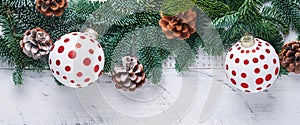 Christmas Decoration. Holiday Decorations with gold baubles, cones, bells, fir branches and present on the old white wooden board