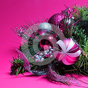 Christmas Decoration. Hot Pink and Silver Balls on Christmas tree branch over magenta background. Holiday Card