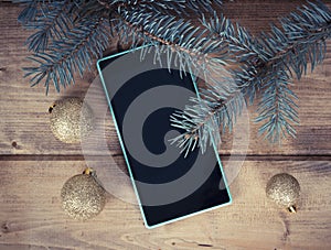 Christmas decoration with the mobile phone on wooden background