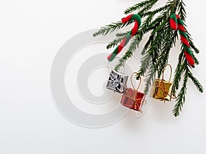 Christmas decoration or ornament laid in rectangular frame shape composed of green pine branch, red and green cane, and gold, silv