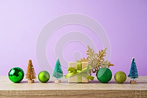 Christmas decoration and ornament on wooden shelf over violet background. New Year holiday greeting card