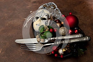 Christmas Decoration ornaments on black plate with silver cutlery set , rustic copper background