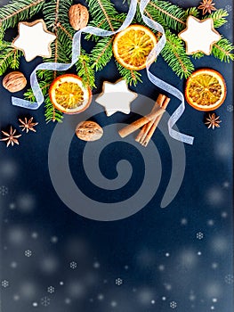Christmas decoration over dark wood background. Top view of homemade butter nuts star shaped cookies with icing, pine, orange