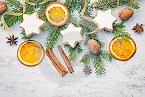 Christmas decoration over white wood background. Top view of homemade butter nuts star shaped cookies with icing, pine, orange