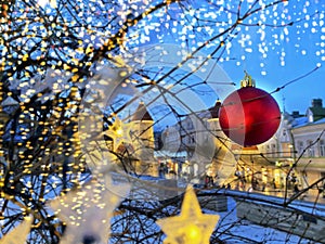 Christmas decoration in rainy city street ,people walking,romantic senior couple under umbrellas in Tallinn old town evening blurr