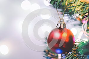 Christmas decoration. Red balls hanging on pine branches christmas tree garland and ornaments over abstract bokeh background with