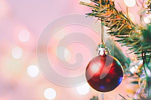 Christmas decoration. Red balls hanging on pine branches christmas tree garland and ornaments over abstract bokeh background with