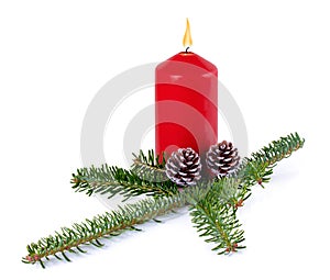 Christmas decoration - red burning candle, spruce branch and cones isolated on white background with shadow reflection.