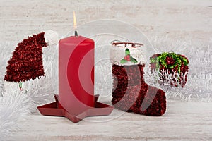 Christmas decoration with red candle on white wooden background