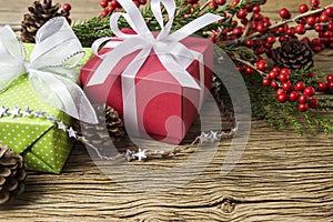 Christmas decoration of red gift box and winterberry on old wood