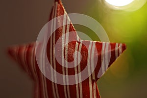 Christmas decoration. Red star hanging on xmas tree. Lights. Background bokeh.