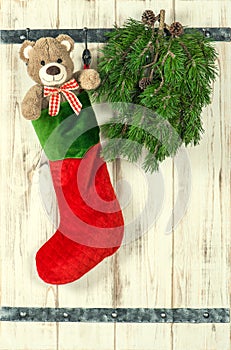 Christmas decoration. Red stocking, Teddy Bear and green pine tr