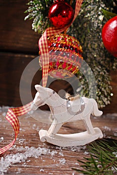 Christmas decoration with rocking horse toy on wooden background