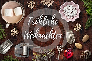 Christmas decoration on rustic wooden background and the German message for `Merry Christmas`