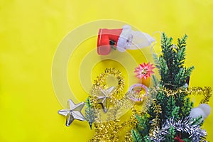 Christmas decoration. Santa`s boot,red ball, fir tree branches with cones and christmas toys on yellow background. Top view