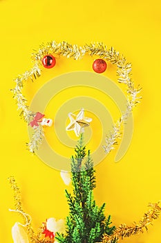 Christmas decoration. Santa`s boot,red ball, fir tree branches with cones and christmas toys on yellow background. Top view