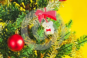 Christmas decoration. Santa`s boot,red ball, fir tree branches with cones and christmas toys on yellow background. Top view