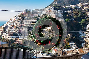 Christmas decoration with scenic view of the colorful houses of the coastal town Positano on the Amalfi Coast in Campania, Italy