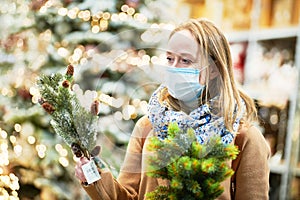 christmas decoration shopping. woman in mask buying new year decor in shop