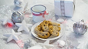 Christmas decoration with silver gifts and home-made cookies and a cup of milk