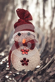 Christmas Decoration snowman on shiny silver christmas paper close up. Art Christmas Greeting Card