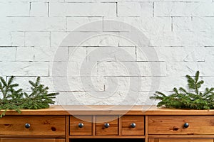 Christmas decoration with space with twigs of spruce on an shelf on the background of a brick wall