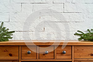 Christmas decoration with space with twigs of spruce on an shelf on the background of a brick wall