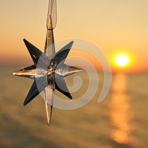 Christmas decoration star on the background of the sunset on the sea. Square