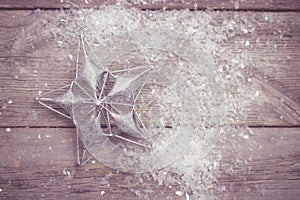 Christmas decoration star shaped on wooden background with snow