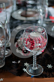 Christmas decoration, table decoration. Wine glasses decorated with candles