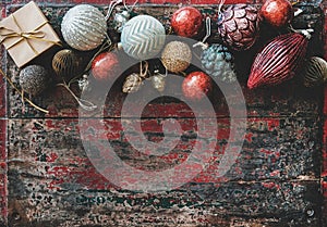 Christmas decoration toys and balls over red rustic wooden background