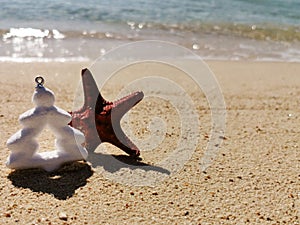 Christmas decoration tree with starfish on summer beach. new year on golden sand