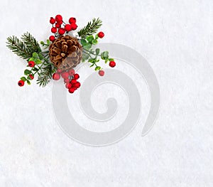 Christmas decoration. Twigs christmas tree, brown natural pine cone and red berries on snow with space for text.