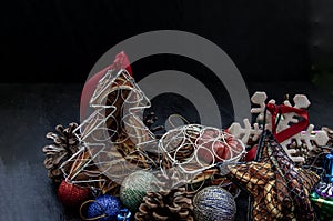 Christmas decoration. Twigs christmas tree, brown natural pine cones and and Xmas deer with variety of fruits on dark background.