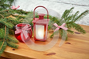 Christmas decoration with twigs of spruce and lantern on an shelf on the background of a brick wall