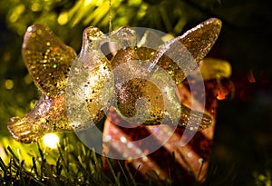 Christmas decoration of two turtle doves kissing in a tree in front of a wrapped present.