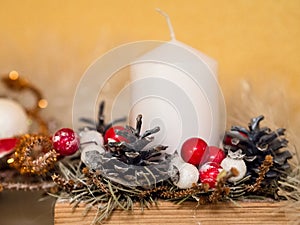 Christmas decoration. White candle, cones, red and white balls