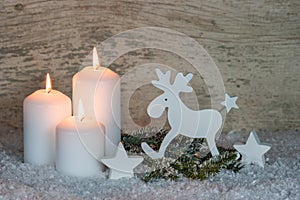 Christmas decoration with white candles and humorous elk decoration