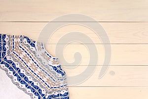 Christmas decoration wooden background with knitted wool sweater with jacquard ornament in white blue and beige. Card concept.