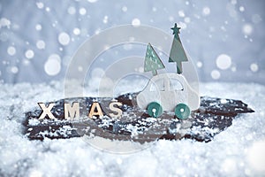 Christmas decoration with wooden car and XMAS letters in a miniature snow scene