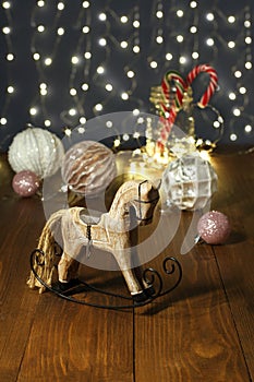 Christmas decoration - wooden toy rocking horse, balls for the Christmas tree, New Year`s candies in a glass jar,