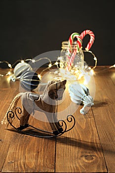 Christmas decoration - wooden toy rocking horse, balls for the Christmas tree, New Year\'s candies in a glass jar