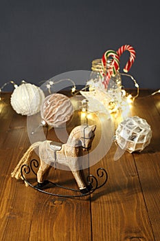 Christmas decoration - wooden toy rocking horse, balls for the Christmas tree, New Year\'s candies in a glass jar