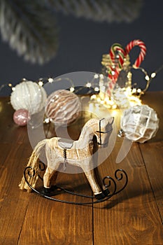 Christmas decoration - wooden toy rocking horse, balls for the Christmas tree, New Year`s candies in a glass jar, garland