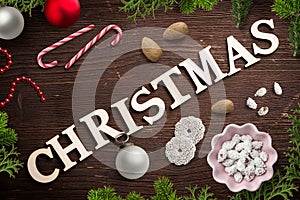 Christmas decoration and the word `christmas` on wooden background