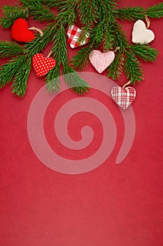 Christmas decoration with xmas ornaments, pine tree, gifts with copy space over the red background