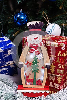 Christmas decorations against blurred background. Small wooden snowman. Rustic wooden snowman snowflake Close up of happy snowman