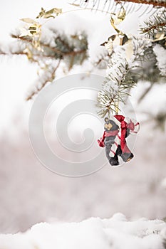 Christmas decorations on a beautiful tree with snow, outdoors. Season holidays and celebrations